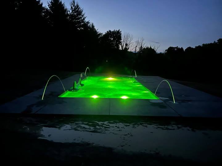 Inground pool with color-changing LED lighting at night
